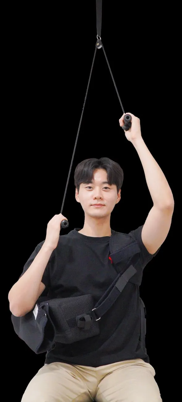 어깨 수술 후 도르래를 이용한 재활 운동. 천장에 매단 도르래에 줄을 걸어 반대쪽 팔로 잡아당겨 수술한 팔을 들어 올린다.