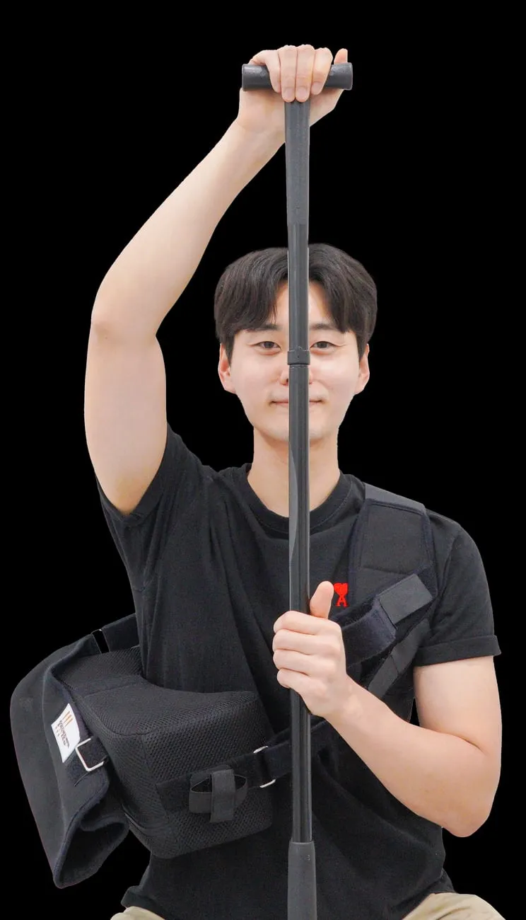 어깨 수술 후 T바(지팡이)를 이용한 재활 운동. 반대쪽 팔로 T바를 밀어 올려 수술한 팔을 들어 올린다.